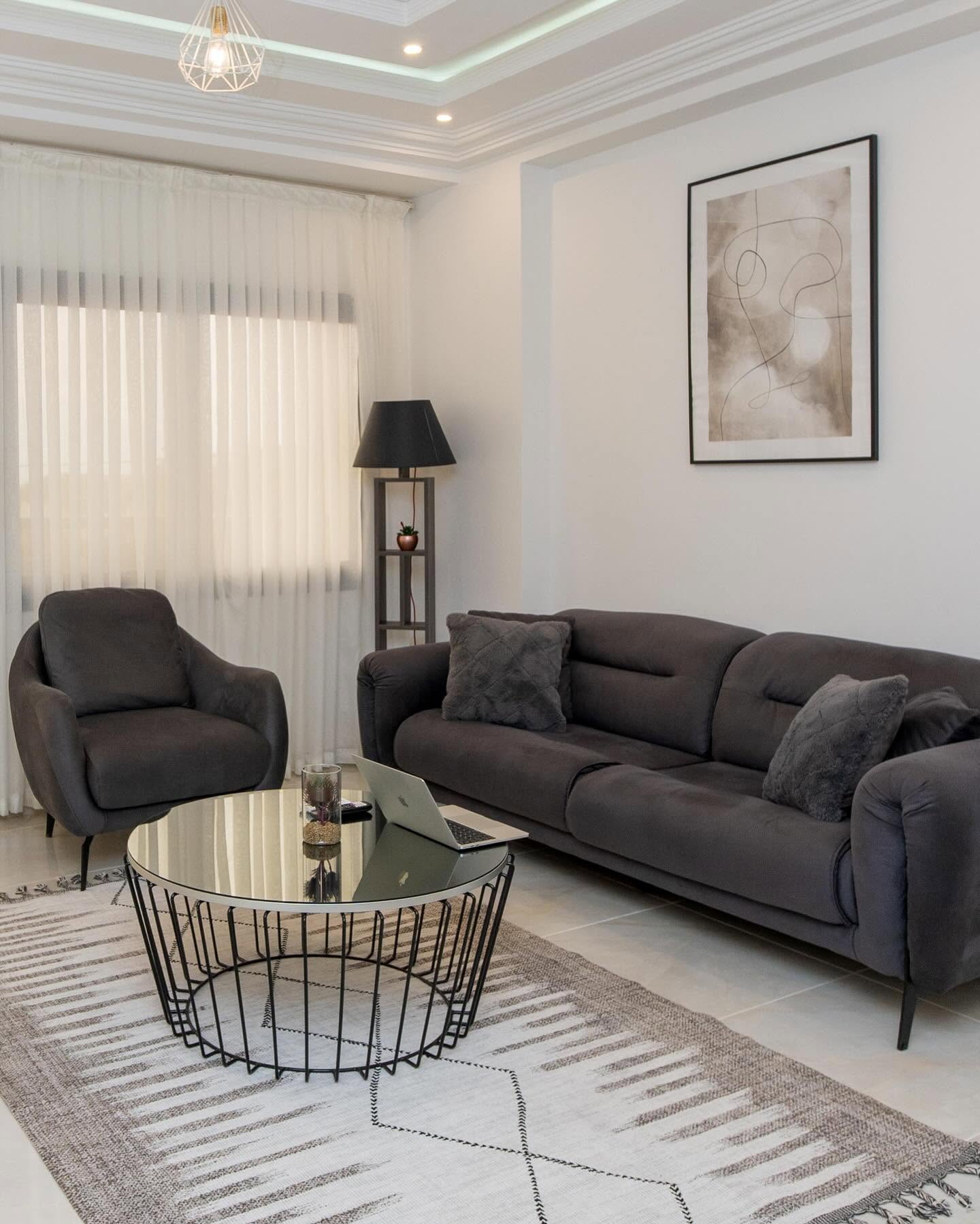 Séjour Sky Residence avec fauteuil, tapis berbère et table ronde