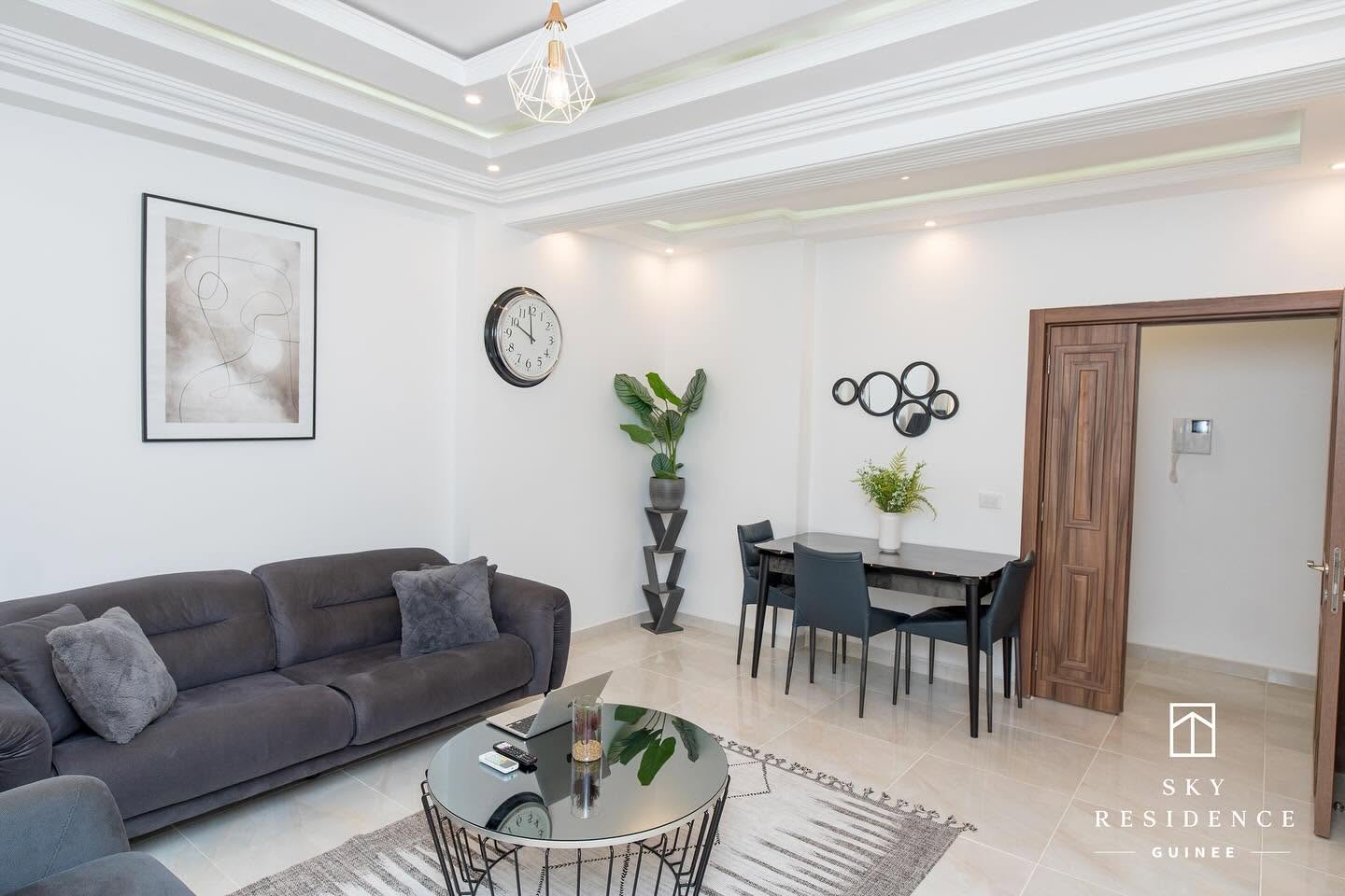 Pièce de vie Sky Residence avec faux plafond lumineux et accès chambre